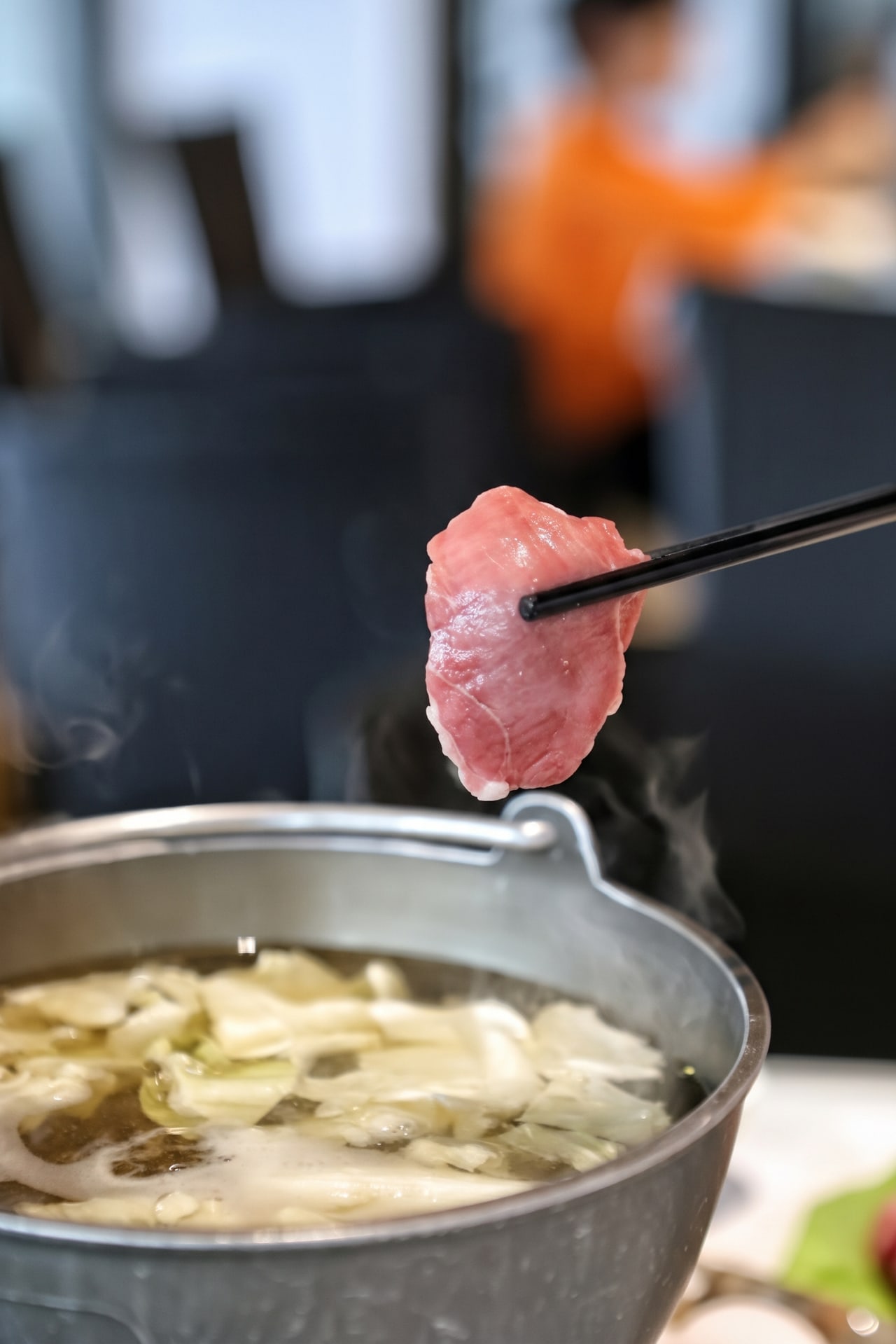 野牛火鍋,筷子夾起牛肉,搭配冒著熱氣的鍋物