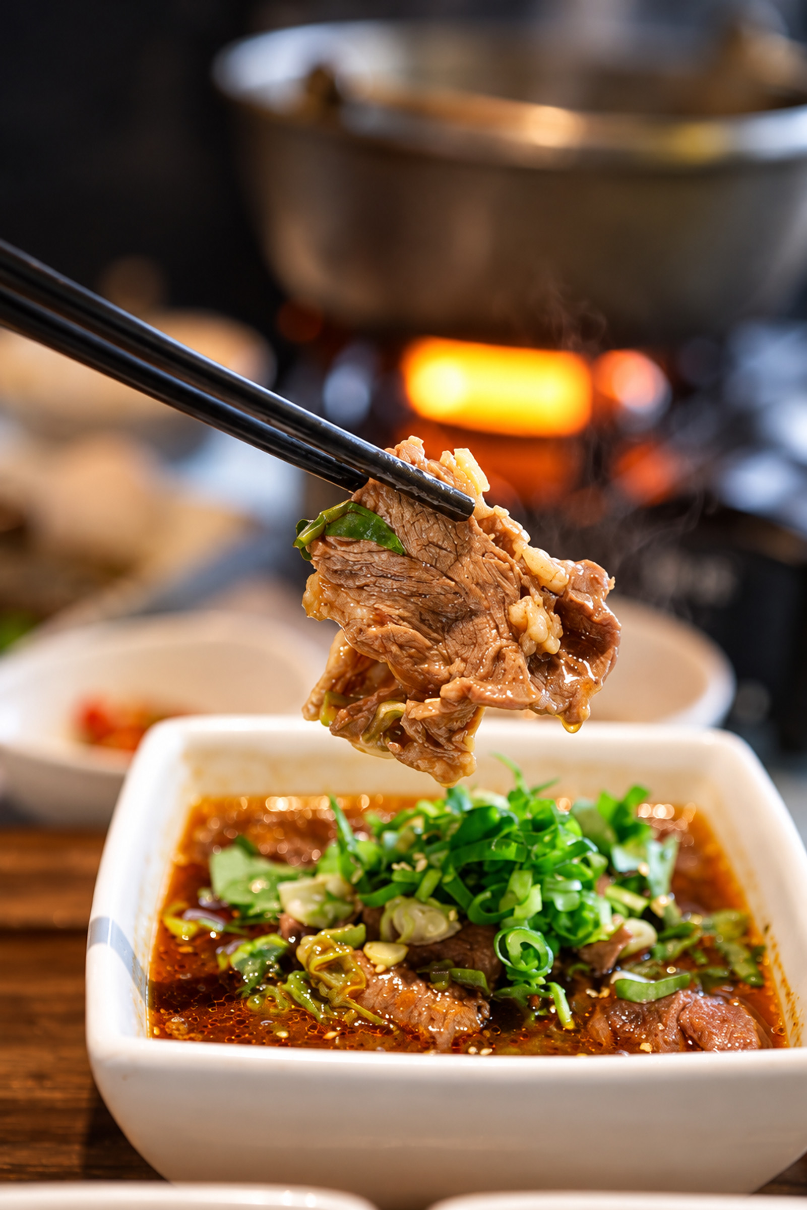 水煮椒香牛肉簡餐,筷子夾起牛肉,碗中搭配椒香湯汁與香菜
