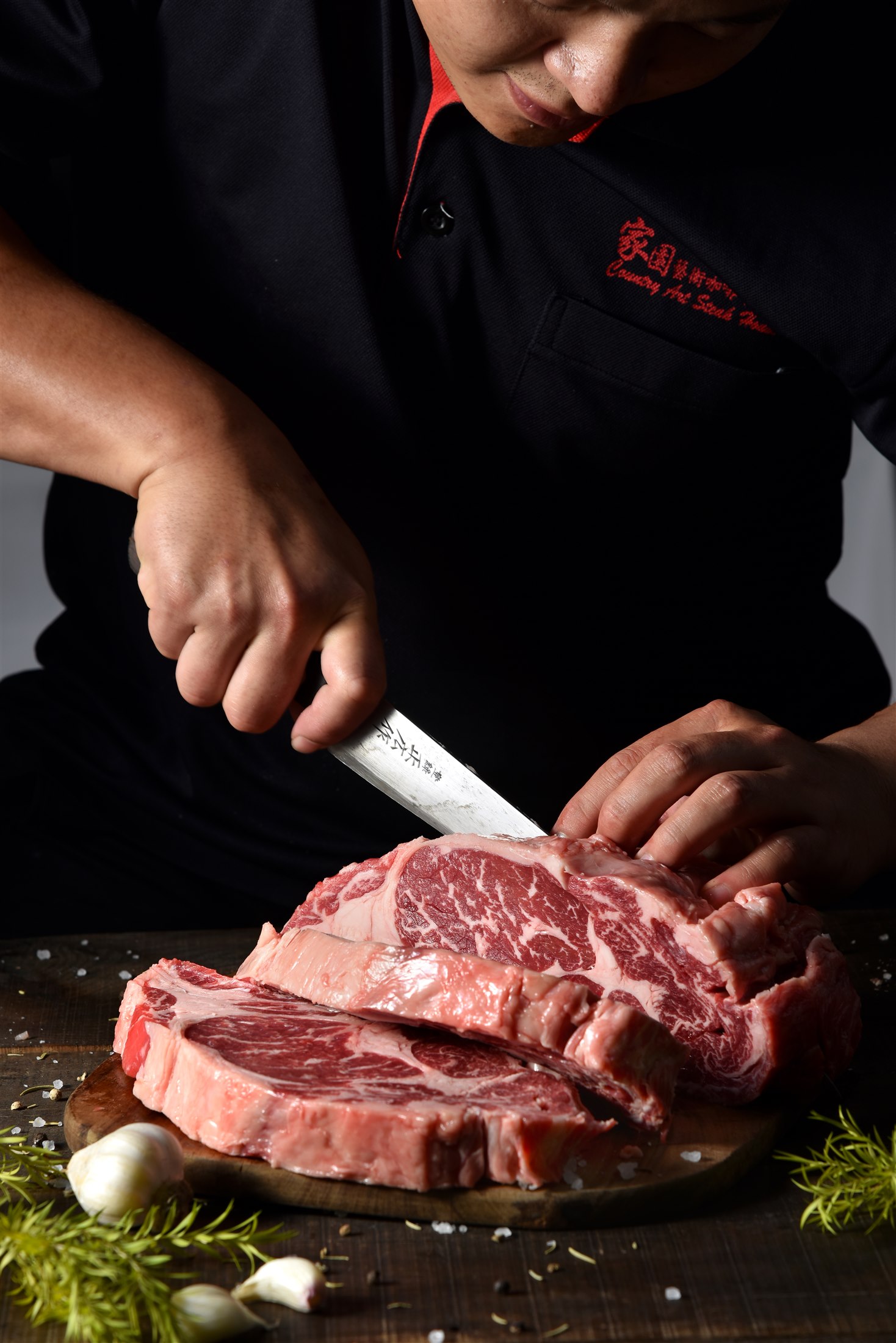 家園師傅穿著店名制服,親手修清與裁切牛肉,手、刀與肉品完整入鏡